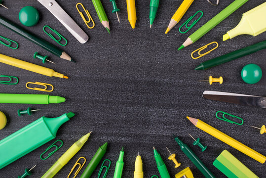 Top above overhead view close-up photo of green and yellow stationery isolated on blackboard with copyspace