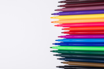Top above overhead view photo of colorful markers without caps on placed to the right side isolated on white background