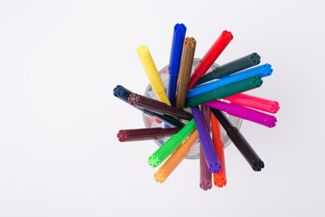Top above overhead view photo of colorful markers in pencil cup isolated on white background