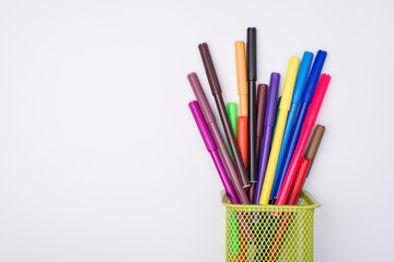 Drawing supplies concept. Top above overhead view flat-lay photo of colorful markers in pencil cup isolated on white background