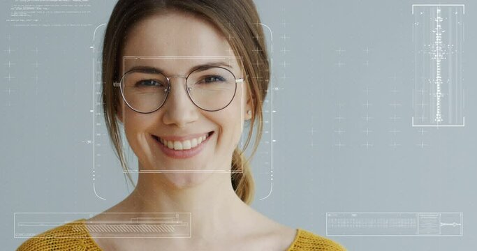 Portrait of young pretty happy woman in glasses with identification of biometric. Facial recognition. Female face scanning. Futuristic 3D identificating of face Close up of beautiful girl on gray
