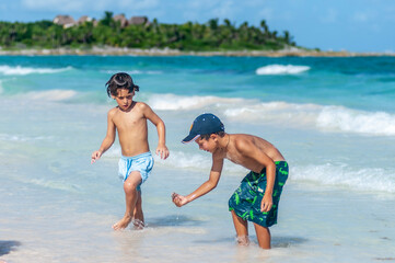 Niños buscan cangrejoes en playa, vacaciones de verano