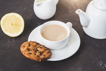breakfast with tea in white cup with lemon and milk/breakfast with tea in white cup with lemon and milk on a dark table
