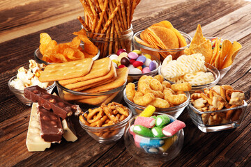 Salty snacks. Pretzels, chips, crackers in glass bowls on table
