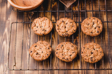 Cooling rack with chocolate chip cookies/Cooling rack with chocolate chip cookies on wooden background, top view