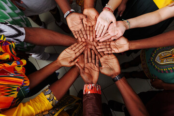 Palms up hands of happy group of multinational African, latin american and european people which...