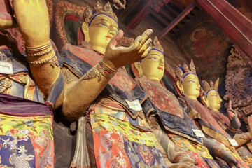 Gold Buddha statues in Tibetan temple huge with hand gestures, Asia