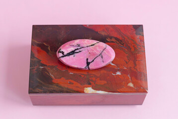 brooch rhodonite on a gem stone jewelry box on pink background