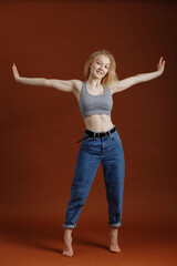 Model test with young beautiful blond woman on brown backdrop, isolated, natural