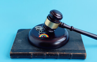 brown gavel and rainbow pendant as an LGBT symbol, concept of minority protection