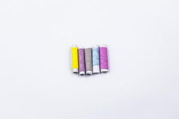 Coloured sewing threads on white background.