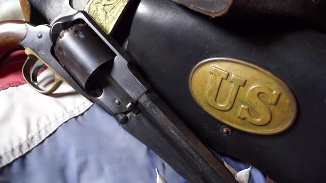 American Civil War hat of the Union Army, pistol and other relics and weapons on a US flag