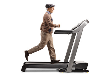 Full length profile shot of an elderly man exercising on a treadmill