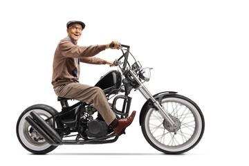 Fototapeta na wymiar Elderly man riding a custom chopper motorbike and smiling at the camera