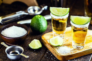 Mexican gold tequila with lemon and salt on wooden background. International tequila day, Bar Drink Establishment