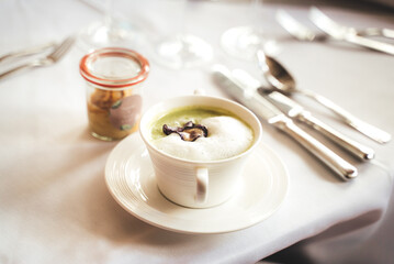 White modern soup mug of green pea cappuccino soup served on festive table. Celebration, party, birthday or wedding concept.