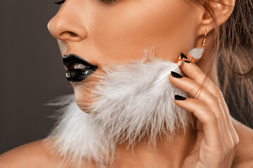 Woman with beautiful makeup and black lipstick on her lips, in the Gothic style. She has white...