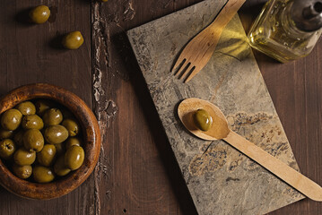 olives and olive oil over a wood background