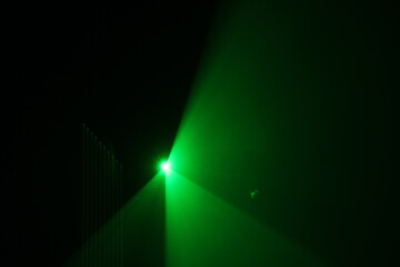 green beam  laser beam on dark background