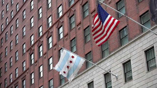 US and Chicago Flag in Slow motion on side of building in Chicago