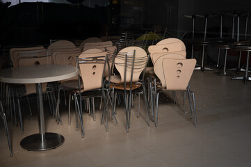 Chairs and tables in a stack at closed cafe caused by coronavirus quarantine