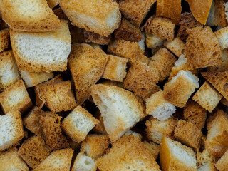 Selective focus on slices of fried white bread close-up. Tasty rosy croutons. Abstract food background.