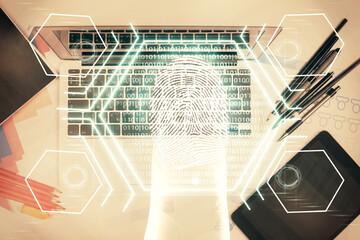 Obraz premium Finger print over computer on the desktop background. Top view. Double exposure. Concept of securitization.