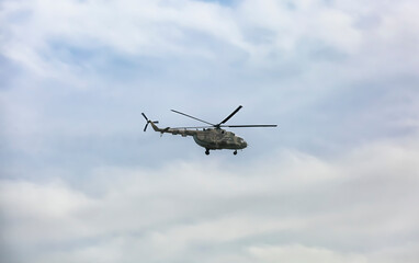 Distant view of military helicopter flying in sky