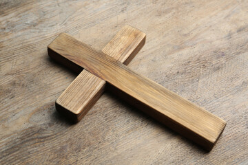 Christian cross on wooden background. Religion concept