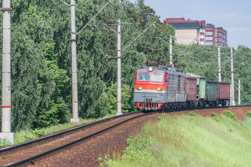 Freight train moves by the spring forest.