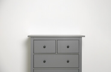 Grey chest of drawers on light background