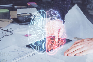 Double exposure of man's hand holding and using a digital device and brain hologram drawing. Data concept.
