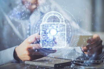 Multi exposure of man's hands holding and using a digital device and lock drawing. Security concept.