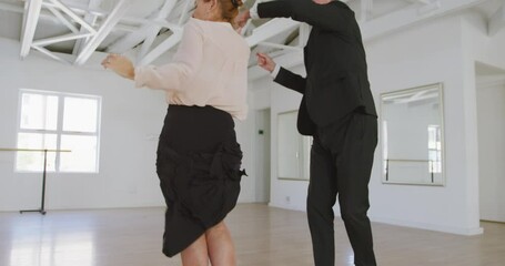 Caucasian senior couple spending time together dancing in a ballroom - Powered by Adobe