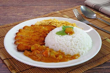 Pork cutlet curry rice (Tonkatsu curry rice, Katsu Kare), Popular Japanese food. Japanese fried crispy pork cutlet (Tonkatsu) served with curry, scrambled eggs and Japanese rice.