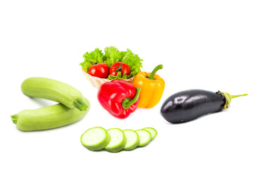 Ripe fresh organic vegetables in dew drops isolated on a white background. Tomatoes, whole and sliced zucchini, bell peppers, eggplant and salad isolated on a white background.