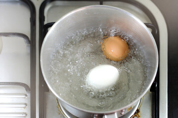 Boil eggs in a pot of boiling water.