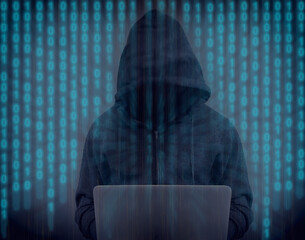 A hacker in a hoodie with laptop and code - anonymous 