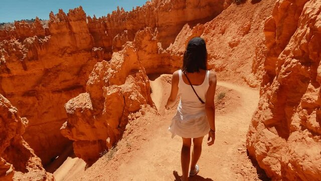 Following a female traveler walking around the Grand Canyon sole in Arizona, traveling around United States, red rocky cliffs