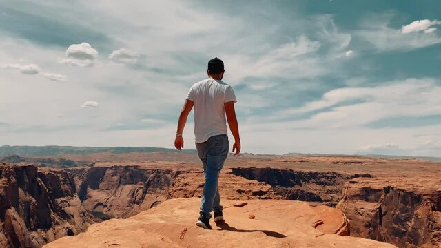Following a male traveler to the edge of Horseshoe bend canyon, traveling around United States, another planet landscape