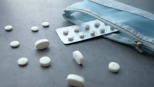 Close up of white pills spilling on dray desk 