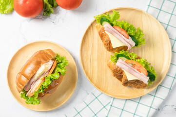 Delicious croissants sandwich with fresh Ham, cheese,  tomato, cucumber, lettuce  and Sub sandwich with fresh salad, Ham , cheese on white background. Top view with copy space. Flat lay.