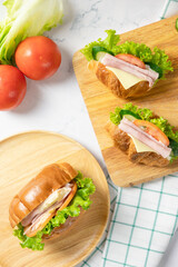 Delicious croissants sandwich with fresh Ham, cheese,  tomato, cucumber, lettuce  and Sub sandwich with fresh salad, Ham , cheese on white background. Top view with copy space. Flat lay.
