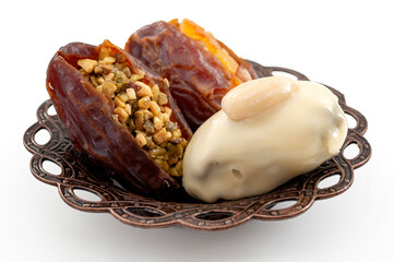 Ramadan sweets, eid mubarak and luxurious desserts concept with stuffed dates on metal plate...