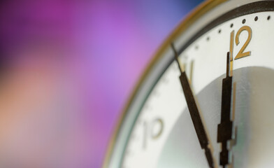 The clock face of an old clock shows the time five minutes before noon