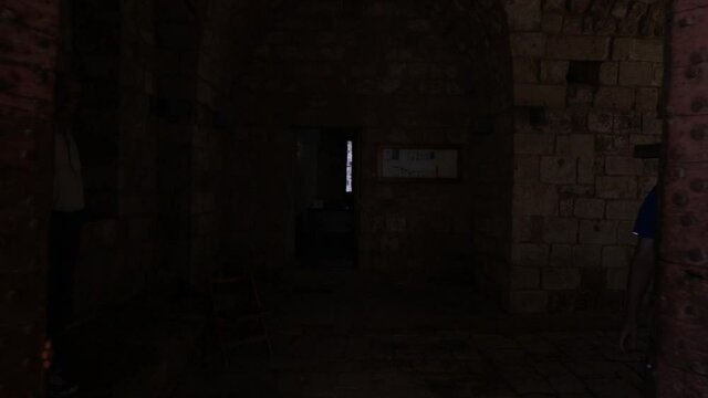 Opening large wooden medieval doors to Tripoli fortress castle into black eerie darkness, fear concept