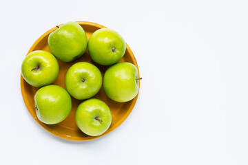Fresh green apples on yellow plate on white background.