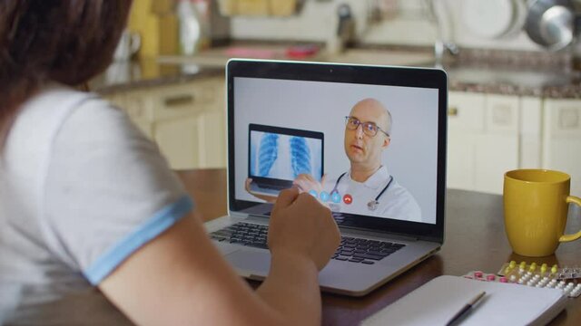 Practitioner doctor consulting by telemedicine online. Doctor explaining lung xray diagnosis by video call for patient. Patient consulting with medical specialist while coronavirus pneumonia