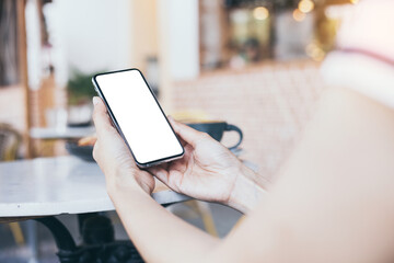 cell phone mockup image blank white screen.woman hand holding texting using mobile on desk at coffee shop.background empty space for advertise.work people contact marketing business,technology