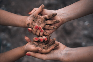 The girl holds in her hands the hands of a child. International family. Help to refugees. Social problems of children.